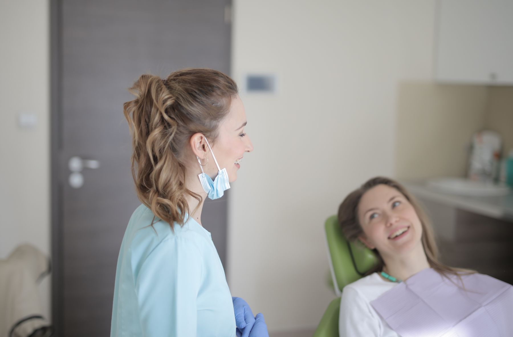 Dentista conversando com paciente em uma clínica moderna